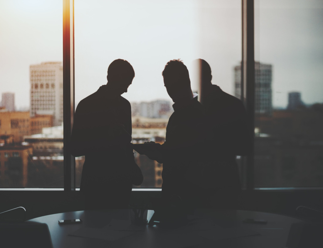 Silhouette von Interim Managern bei der Planung in großem Bürogebäude